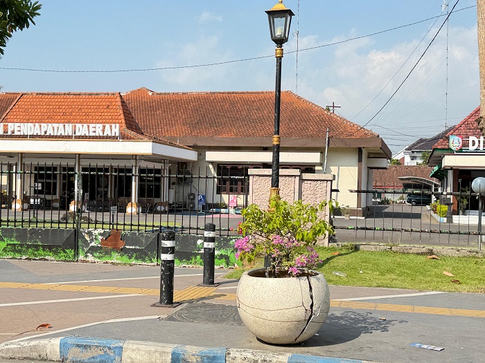 RUSAK: Kondisi pot bunga trotoar Jl KH Wahid Hasyim, Jombang yang rusak diikat kawat.