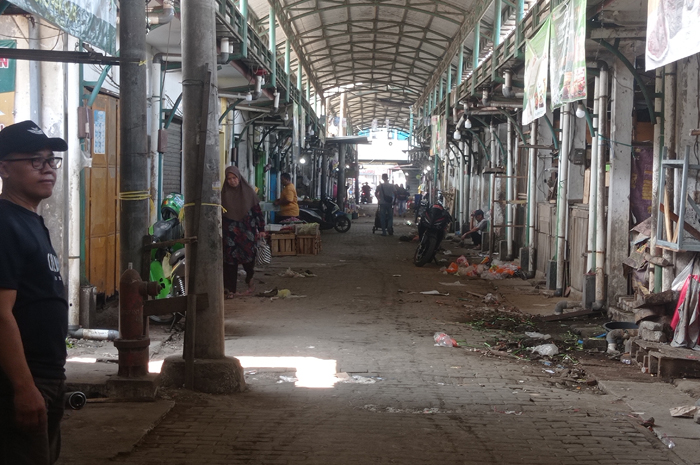 JADI AKSES PROYEK: Pedagang berjualan lorong Pasar Ploso, Jombang membersihkan lapaknya karena bakal digunakan keluar-masuk kendaraan proyek.
