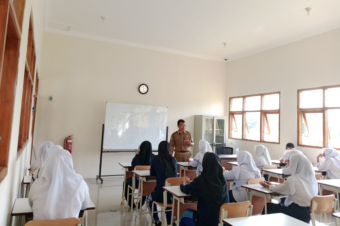 MENGABDI: Andik Minarto, Kepala Sekolah Rakyat Jombang saat mengisi materi dalam kelas.