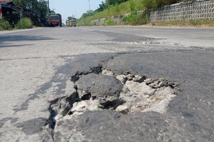 BERLUBANG: Kondisi cor jalan kabupaten ruas Kasemen-Gudo di Desa Wangkalkepuh, Kecamatan Gudo, Jombang, rusak.