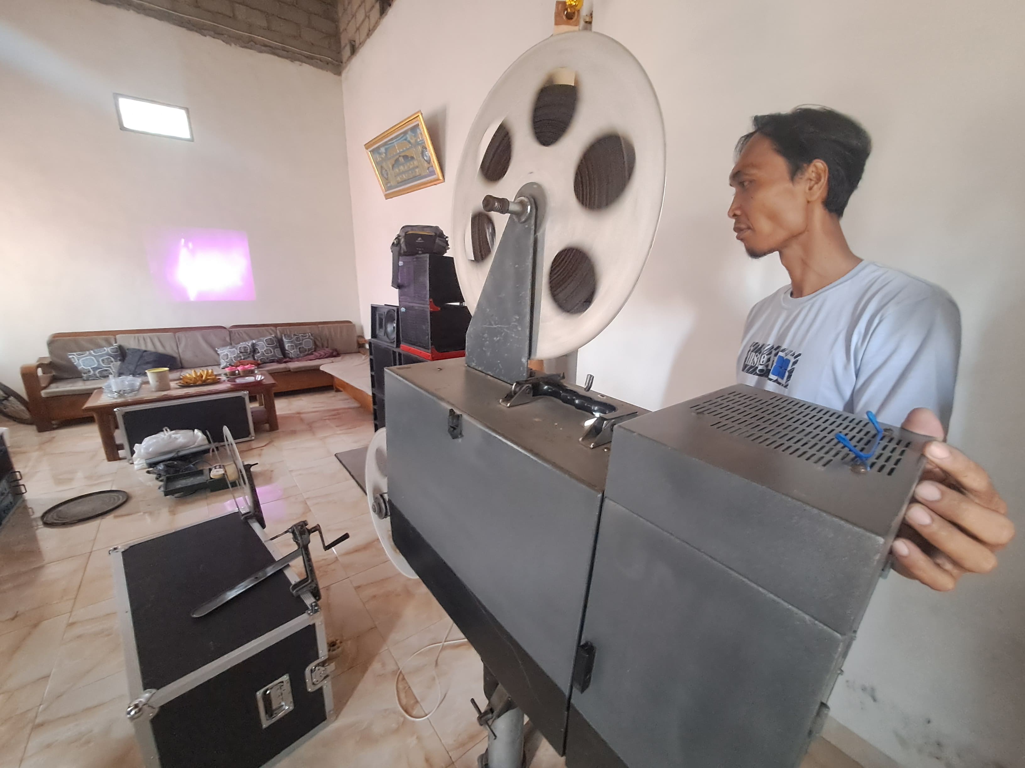 NOSTALGIA: Slamet tengah menunjukkan mesin pemutar film jadul yang ia punya di rumahnya.