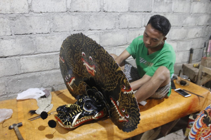 KEBUT PESANAN: Tariske Valentine 23, warga Dusun Sanggar, Desa Galengdowo, Kecamatan Wonosalam saat membuat kerajinan barongan jepaplok.