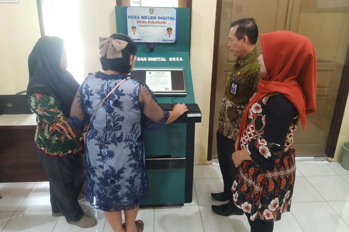 LAYANAN DIGITAL: Kepala Desa Pulosari Nefi Ufus Solikah bersama Camat Bareng Usman mendampingi salah satu warga saat melakukan pelayanan secara digital.