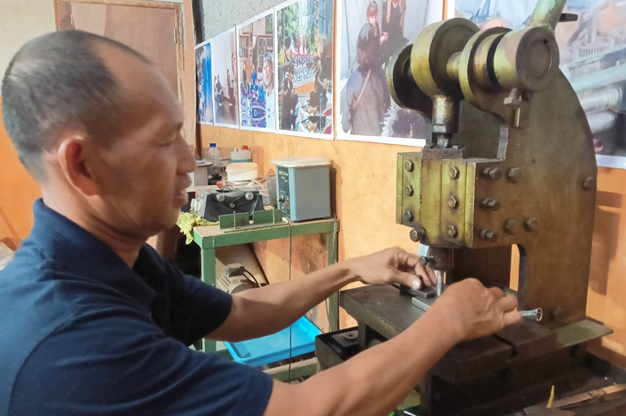 KREATIF: Eko Cahyono 48, perajin berbahan logam asal Desa Sumberjo, Kecamatan Wonosalam, Jombang tetap eksis hingga sekarang.
