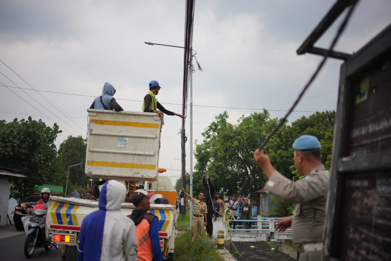 DITERTIBKAN: Petugas gabungan menertibkan keberadaan kabel fiber optic yang semrawut di Jombang.