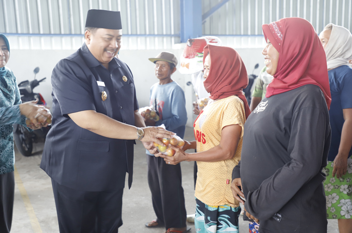 PEDULI: Bupati Warsubi membagikan tomat gratis ke warga di TPA Gedangkeret Banjardowo, Kecamatan Jombang, (29/9).