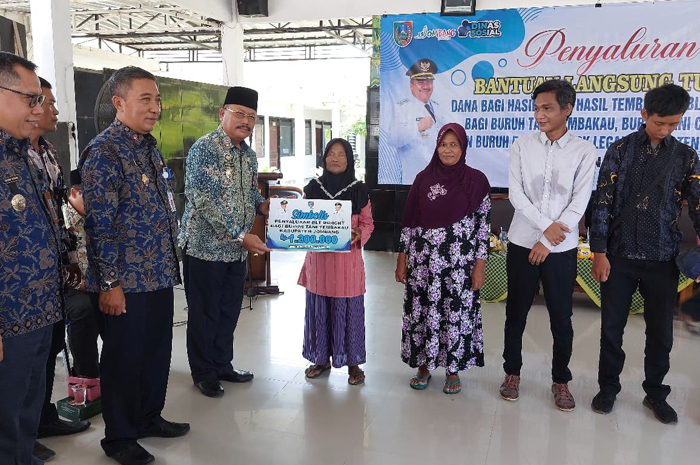 PEDULI: Asisten I Bidang Pemerintahan dan Kesejahteraan Rakyat Setdakab Jombang, Purwanto, yang mewakili Bupati Jombang Warsubi saat menyerahkan BLT DBHCHT 2025, Kamis (9/10).