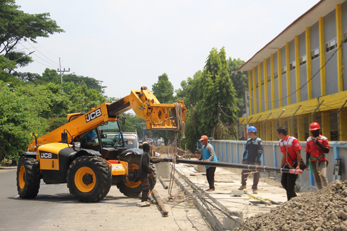 DICABUT: Dinas PUPR Jombang menggunakan alat telehandler untuk mencabut tiang internet di Jl Gubernur Suryo dan Jl Kusuma Bangsa, (13/10).