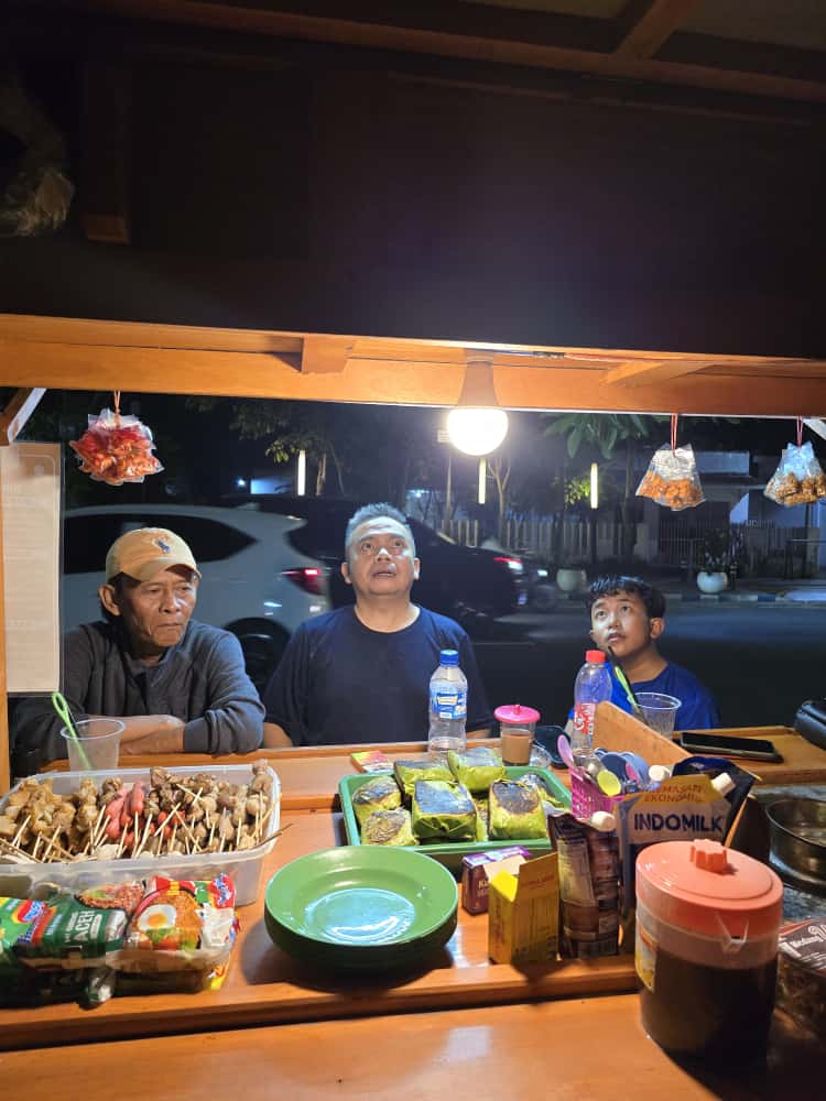 TELADAN: Wakil Ketua DPRD Jombang, HM Syarif Hidayatullah ST MMT (Gus Sentot), menikmati angkringan milik komedian Dika Mbeluk di depan Polres Jombang, Minggu (12/10).