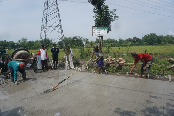 TUNJANG MOBILITAS WARGA: Kepala Desa Kepuhdoko Inasaroh bersama jajaran perangkat dan TPK Desa Kepuhdoko saat meninjau lokasi pembangunan jalan rabat beton di Dusun Kepuh.