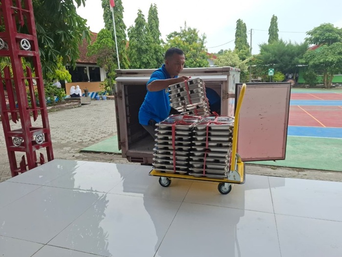 Petugas dari SPPG mengantarkan makanan ke SMPN Kabuh.
