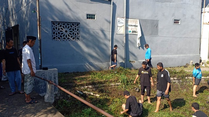 KOLABORASI PEDULI LINGKUNGAN: Kepala Desa Cukir Sawung Agus Basuki memantau kegiatan bersih-bersih lingkungan di wilayah Dusun Tebuireng, Jombang,