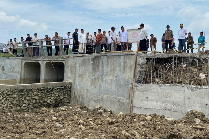 ATENSI: Bupati Warsubi saat melihat jalan cor beton ruas Asemgede di Desa Asemgede, Kecamatan Ngusikan, Jombang, yang ambrol, Kamis (23/10).