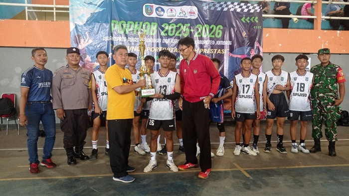 SELAMAT: Ketua MKKS SMP Negeri di Jombang Yony Tri Joko Kurnianto menyerahkan piala ke tim voli putra SMPN 1 Ploso sukses meraih juara satu, Minggu (9/11).