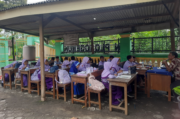 TIDAK LAYAK: Siswa SDN Plosogenuk 1 Kecamatan Perak, Jombang belajar di tempat parkir.