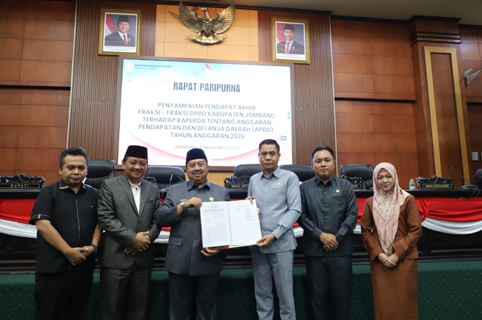SAH: Bupati Warsubi dan Ketua DPRD Hadi Atmaji menunjukkan R-APBD 2026 yang disahkan menjadi perda pada paripurna di DPRD Jombang.