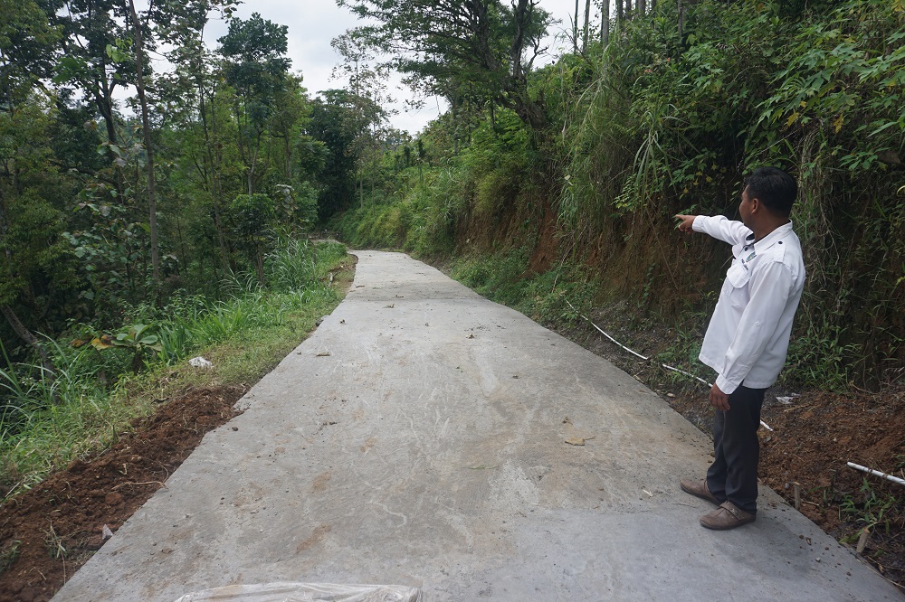 Salah satu perangkat Desa Jarak menunjukkan jalan lingkungan yang telah dirabat beton di Dusun Jarak Krajan.