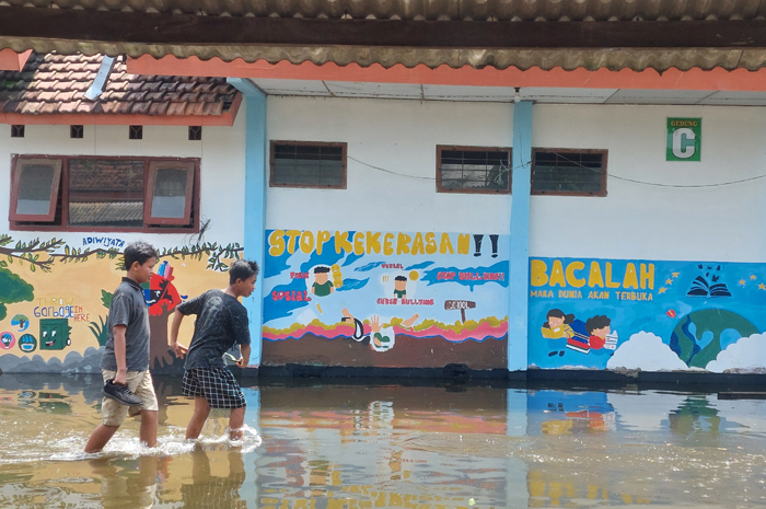 SEKOLAH TERGANGGU: Air menggenangi halaman SMPN 2 Ploso, Jomban, Kamis (20/11)