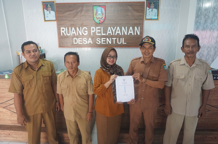 KOMITMEN: Kepala Desa Sentul Misbahul Arifin didampingi jajaran perangkat Desa Sentul saat menunjukkan Perdes Ramah Perempuan dan Peduli Anak.