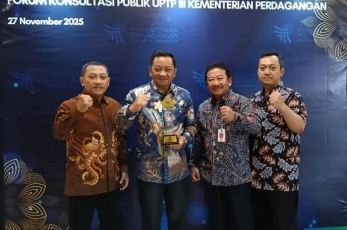SINERGI: Sekdakab Jombang Agus Purnomo didampingi Kepala Disdagrin Suwignyo saat usai menerima penghargaan dari Kemendag RI, Kamis (27/11).