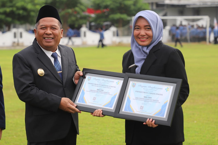 BERPRESTASI: Kepala Puskesmas Cukir, dr Rokhmah Maulidina MKes, menerima piagam penghargaan yang diserahkan Wakil Bupati Jombang, Salmanudin, di Lapangan Pemkab Jombang, Senin (1/12).