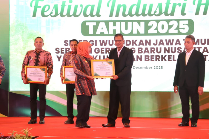 Gubernur Jawa Timur, Khofifah Indar Parawansa, menyerahkan penghargaan kepada Division Head ESG Center PT CJI, Tri Mardi Walyono di Surabaya, Selasa (2/12).