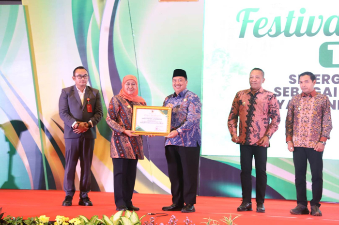 Gubernur Jawa Timur Khofifah Indar Parawansa menyerahkan penghargaan Bupati Jombang Warsubi, di Dyandra Convention Center Surabaya, Selasa (2/12).