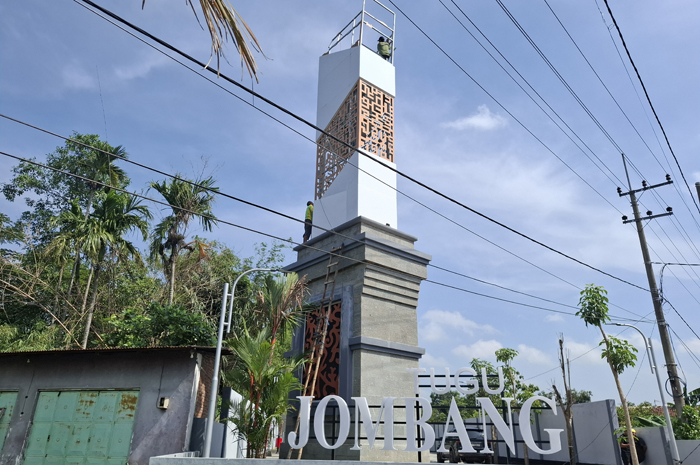 DIBENAHI: Pekerja memperbaiki tugu Jombang di Bandarkedungmulyo yang bagian atasnya ambruk.