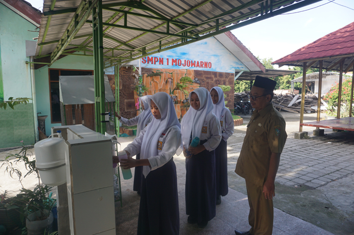 IMPLEMENTASI ADIWIYATA: Para siswa SMPN 1 Mojowarno mengambil air siap minum dan membuang sampah botol plastik di tempat yang telah disediakan dengan didampingi koordinator tim Adiwiyata