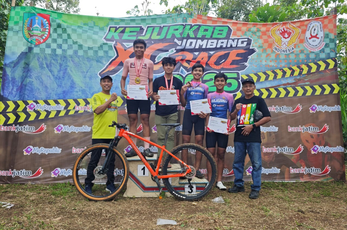 BERPRESTASI: Ketua Umum KONI Jombang, Sumarsono (kanan) menyerahkan piagam kepada juara Kejurkab XCRace di Kandang Kambing Bike Park, Pangklungan, Wonosalam, Minggu (14/12).