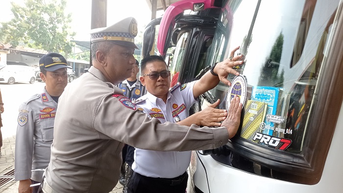 LAIK JALAN: Kepala Dishub Jombang Sugianto didampingi Kanit Kamsel Satlantas Polres Jombang Ipda Ken Wahyu menempel stiker.