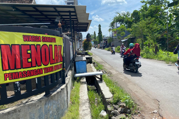 BENTUK PENOLAKAN: Sejumlah banner penolakan pendirian tiang internet terpampang di beberapa jalan strategis antardusun, (26/12).