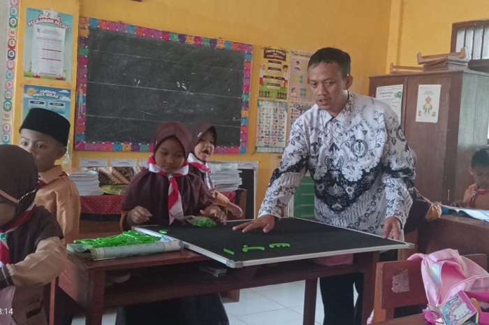 TERAMPIL: Romadhon Rosidi, guru PAI SDN Sugihwaras 1 Kecamatan Ngoro, Jombang saat mengajar di kelas (25/7) .