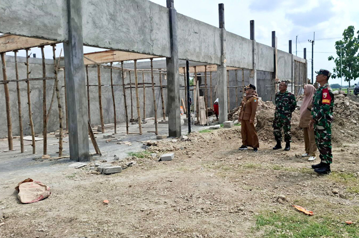 SINERGI LINTAS SEKTORAL: Kepala Desa Ngogri Lis Hartatik bersama jajaran Forkopimcam Megaluh saat meninjau progres pembangunan gedung KDMP Desa Ngogri, Megaluh, Jombang.