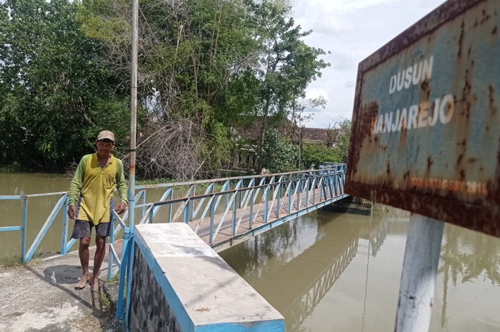 Warga melintas di jembatan Kudubanjar, Kecamatan Kudu, Jombang.
