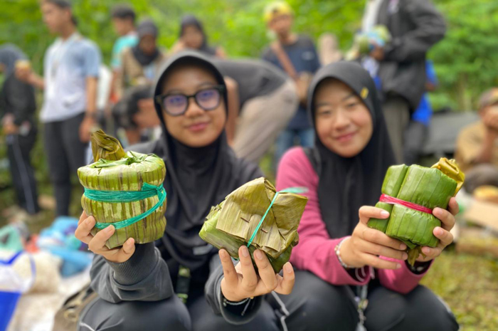 RUKUN: warga Kampung Adat Segunung, Wonosalam, Jombang saat menyantap hasil bekal tradisional di lereng hutan.
