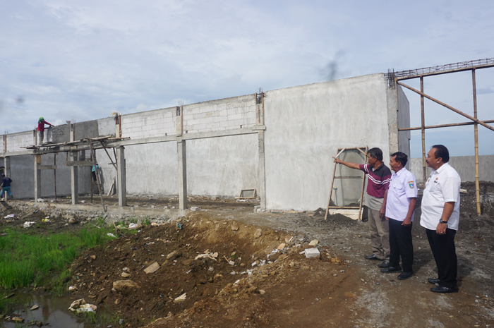 TINJAU PEMBANGUNAN KDMP: Ketua BPD Bugasurkedaleman Suramto menunjukkan progres pembangunan KDMP kepada Kepala Desa Bugasurkedaleman Surawi dan Camat Gudo, Jombang Arief Hidajat.