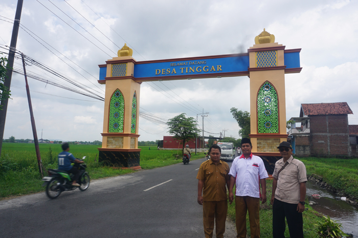 MEGAH: Ketua BPD Tinggar Fathurrozi (tengah) bersama Kaur Perencanaan Desa Tinggar Abdul Wahib (paling kanan) dan Kepala Dusun Banjaranyar Mujianto saat menunjukkan bangunan gapura yang sudah rampung.