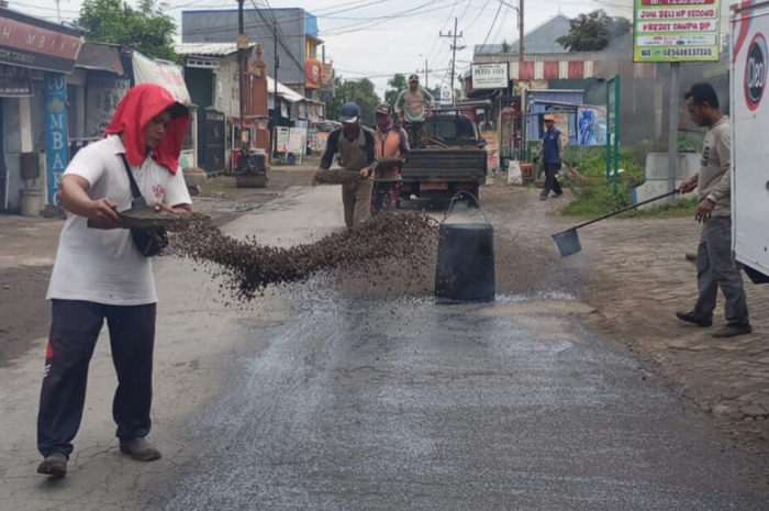 DIPERBAIKI: Tim mandor jalan saat memperbaiki jalan rusak di Jombang.
