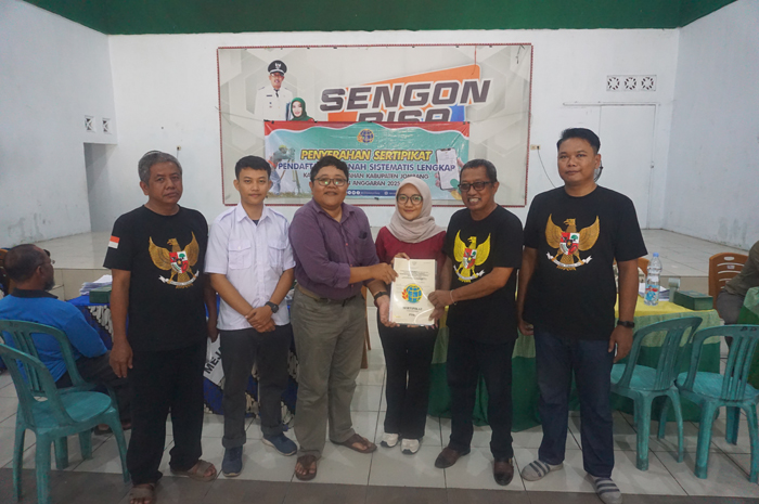 SAH SECARA HUKUM: Kepala Desa Sengon Totok Soetjahjo (dua dari kanan) didampingi jajaran saat memberikan sertifikat PTSL kepada salah satu warga, Jumat (30/1) siang.