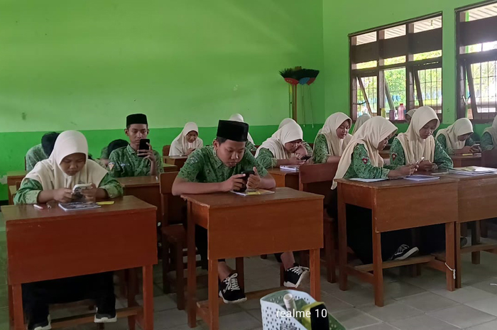 TEKUN: Siswa mengenakan smartphone untuk mengerjakan soal Tryout TKA, Kamis (5/2).