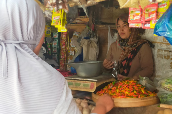NAIK: Pedagang bumbu dapur di Pasar Legi, Jombang melayani pembeli, (9/2).
