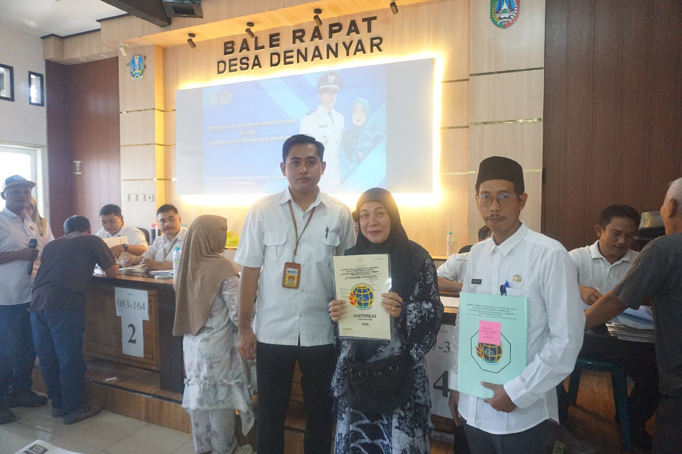 Sekretaris Desa Denanyar M Samsul Arifin (paling kanan) saat menyerahkan sertifikat PTSL kepada warga, Rabu (11/2) pagi.