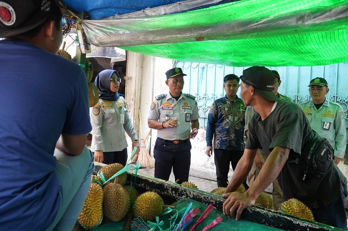 INTERAKTIF: Petugas Dishub Jombang berdialog dengan warga berjualan di atas trotoar.