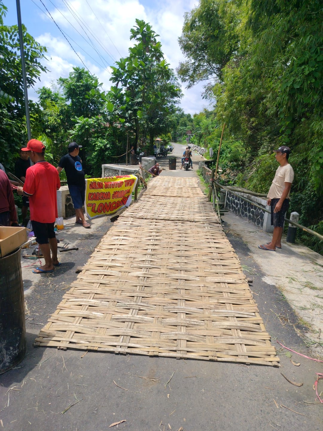 BUTUH PENANGANAN: Warga gotong royong melakukan penanganan darurat jembatan rusak di Dusun Kempreng, Desa Latsari, Kecamatan Mojowarno, Jombang.