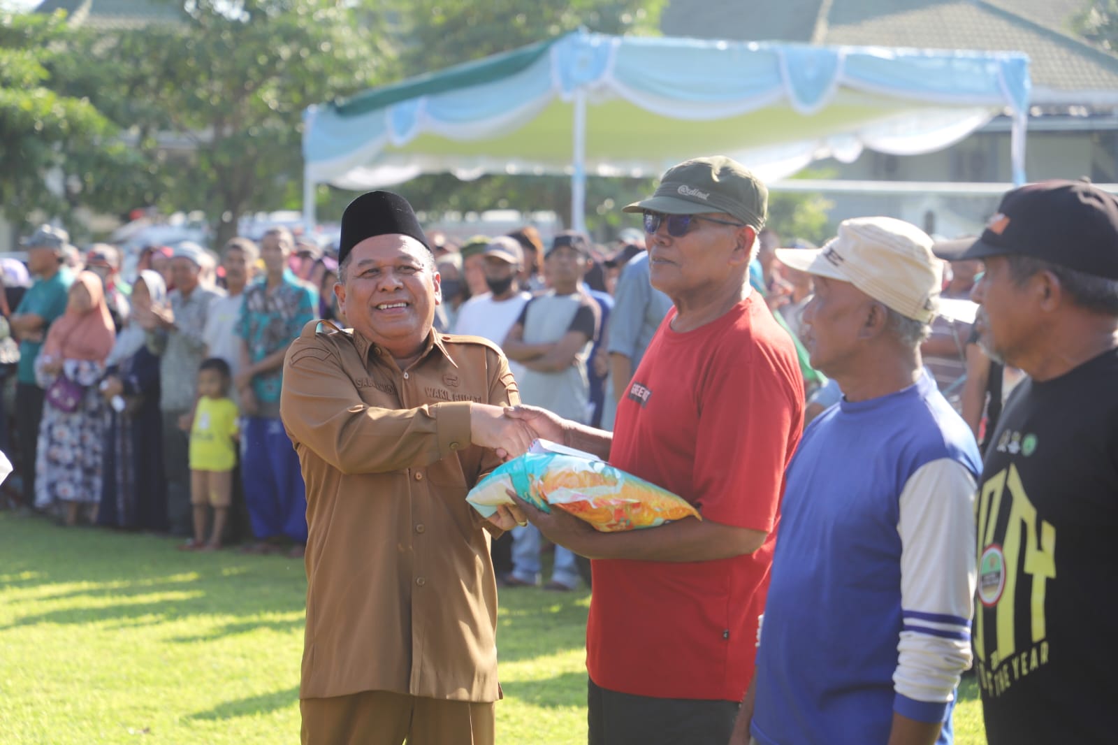 PEDULI: Bupati Jombang Warsubi yang diwakili Wabup Salmanudin, Sekdakab Jombang Agus Purnomo menyalurkan bansos untuk PPKS dan PSKS di Lapangan Pemkab Jombang kemarin (16/3).