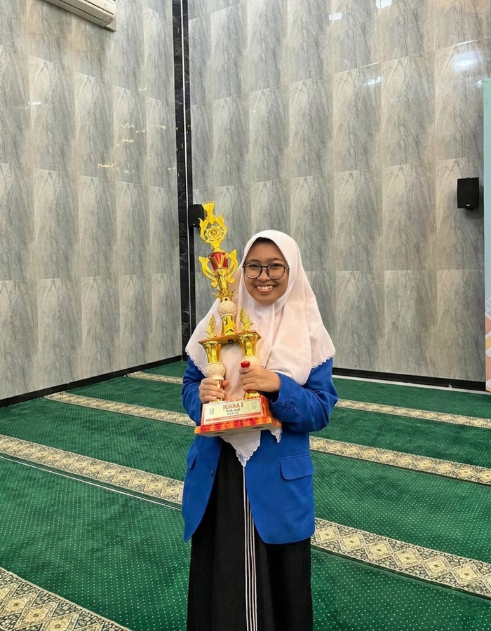 JUARA: Najiha Savira Rahmanillah membawa trofi juara 1 MTQ Jatim 2025.