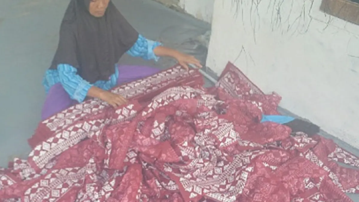 SIAP JAHIT: Warga mengeringkan tas hajatan atau tas parcel Lebaran baru saja disablon di Desa Budugsidorejo, Kecamatan Sumobito, Jombang. (Ainul Hafidz/Radar Jombang)