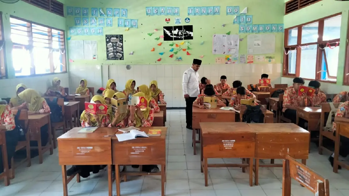 TELATEN: Choirul Anam, pembina ekstrakurikuler keagamaan saat mengajar di SMPN 2 Ngoro, Jombang. (Wenny Rosalina/Radar Jombang)