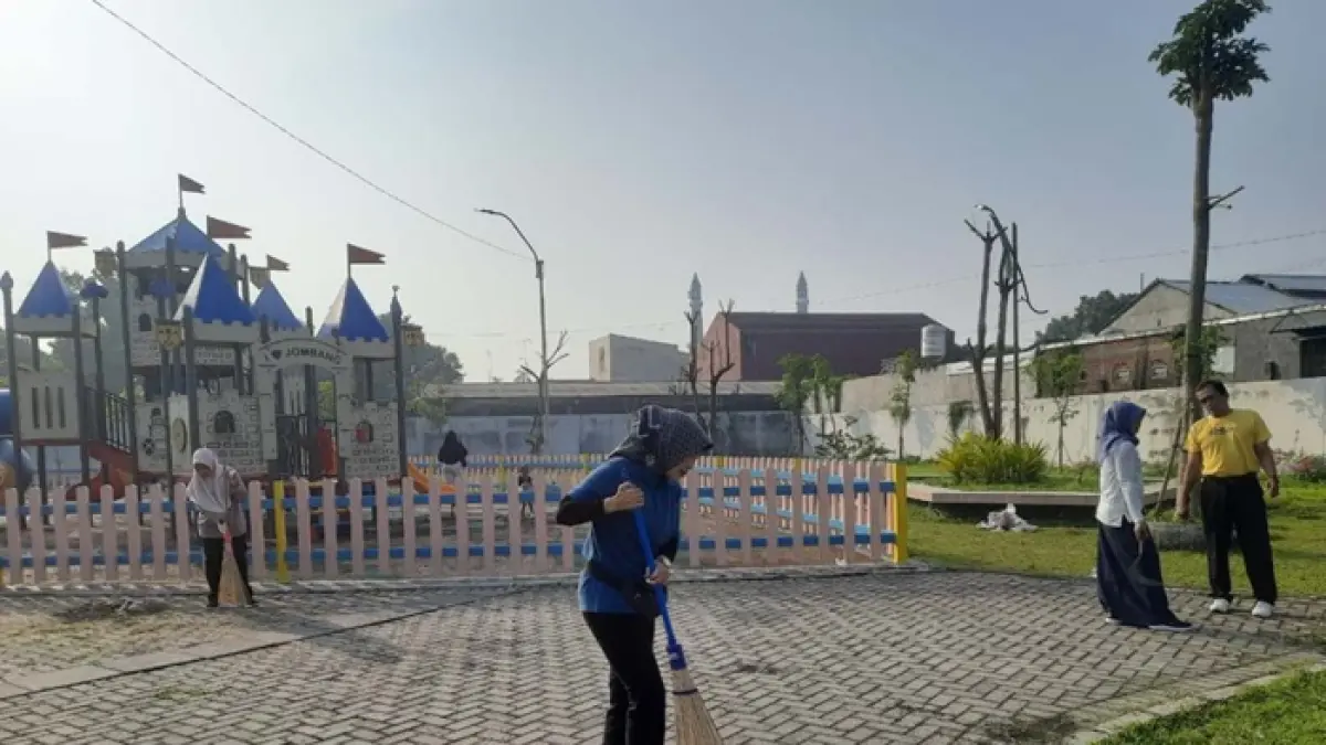 RESIK: Kepala Dinas Pendidikan dan Kebudayaan Jombang, Wor Windari, ikut membersihkan sampah di area sentra PKL Jombang kuliner, (17/6). (Anggi Fridianto/Radar Jombang)